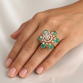 Hand wearing a ring with emerald and diamond design on a light background, lab grown diamond in hyderabad