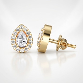 Gold earrings with teardrop-shaped gemstones on a light background, lab grown diamond in hyderabad